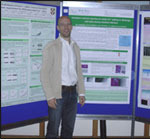 Joint poster prize winner Björn Sieberer smiling and standing next to the winning poster hung up.