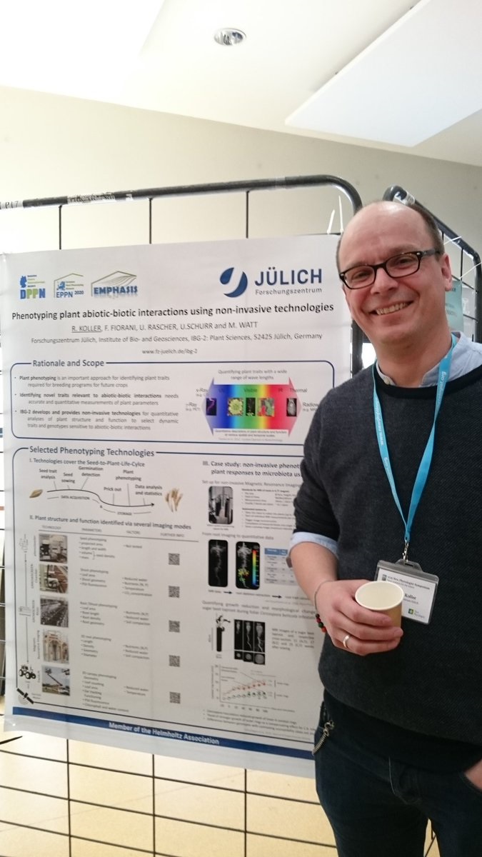 Poster prize runner-up Robert Koller smiling and standing next to the runner-up poster hung up.