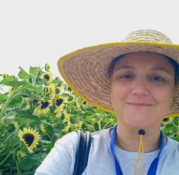 Nicole Creux wearing a sun at stood in front of sunflowers