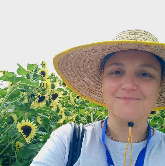 Nicole Creux wearing a sun at stood in front of sunflowers
