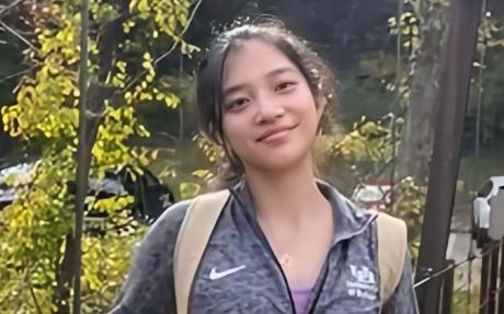 Photo of Qianru Liao, with woodland in the background.