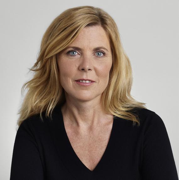 Amy Austin, wearing a black long sleve top in front of a white background