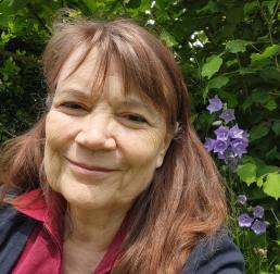 Andrea Polle wearing a red top stood in front of bushes