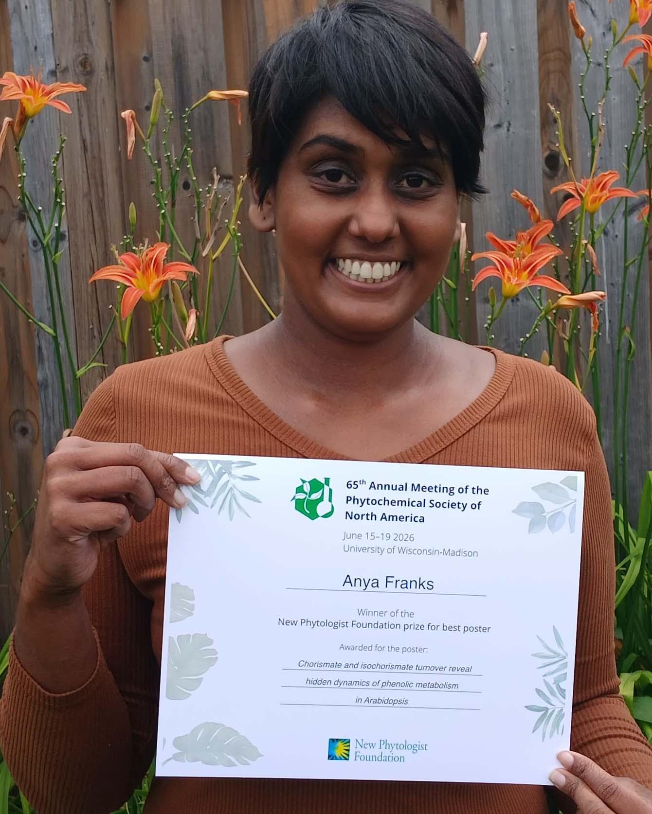 Anya Franks holding a certificate for the New Phytologist Foundation prize for best poster.