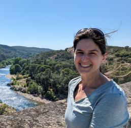 Elizabeth M Wolkovich stood outside in front of a forest and river