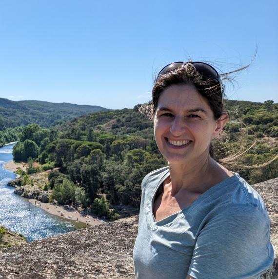 Elizabeth M Wolkovich stood outside in front of a forest and river