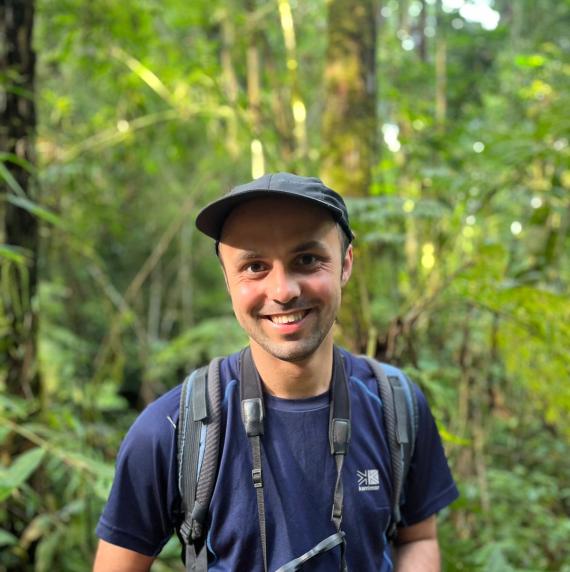 Gianluca	Cerullo holding a pair of binoculars in the forest