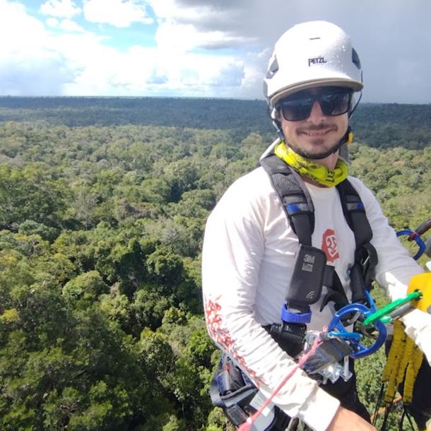Leonardo Ziccardi high above the canopy, as storm clouds roll in over the Central Amazon rainforest.
