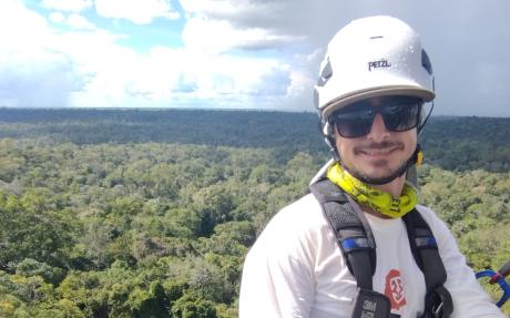 Leonardo Ziccardi high above the canopy, as storm clouds roll in over the Central Amazon rainforest. Photo by Gleison Viana.