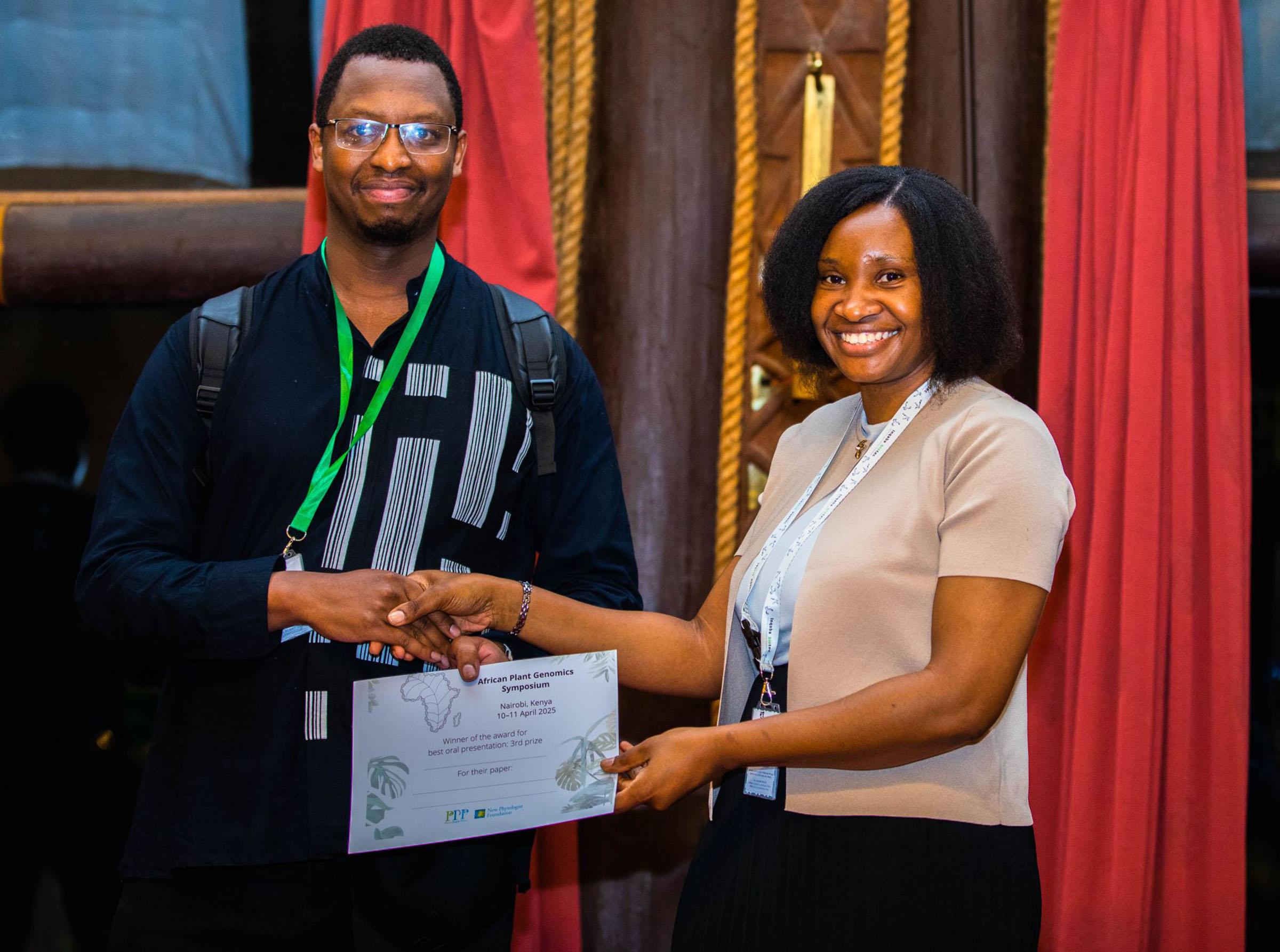 Patience Chatukuta hands Jantor Ndalo, winner of the third prize for best poster at the African Plant Genomics Symposium, a certificate
