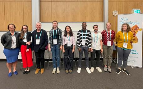 Nine conference delegates stand in a row