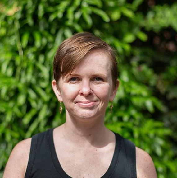 Karolina Heyduk wearing a black top in front of a leafy background