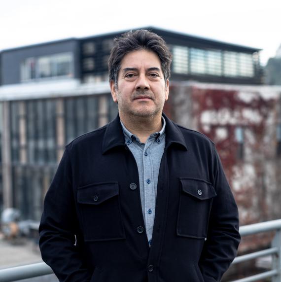 Rodrigo A. Gutiérrez wearing a black jacket stood in front of a building