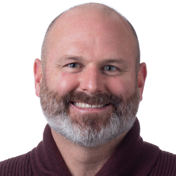 Todd Michael wearing a maroon jumper in front of a white background