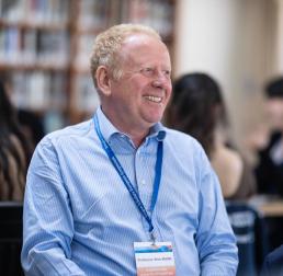 Alex Webb wearing a light blue shirt, sat in a library