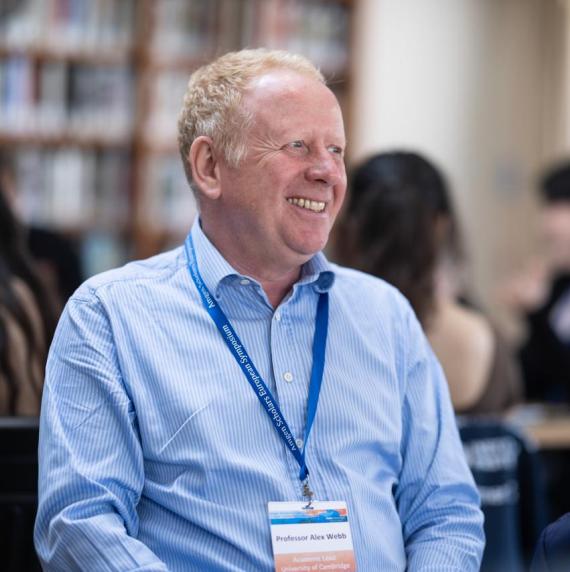 Alex Webb wearing a light blue shirt, sat in a library
