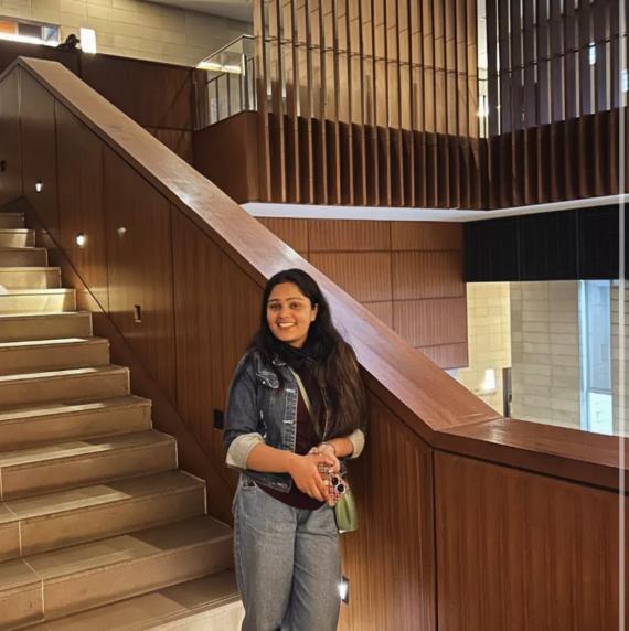 Surbhi	Phulia standing at the bottom of a set of stairs