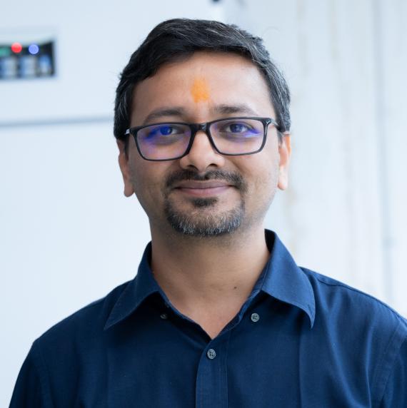 Ashutosh Srivastava in a navy blue shirt in front of a white background