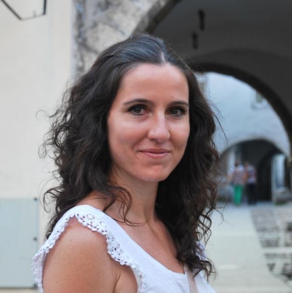 Rocío Hernández-Clemente, in a white top, standing in front of an arch