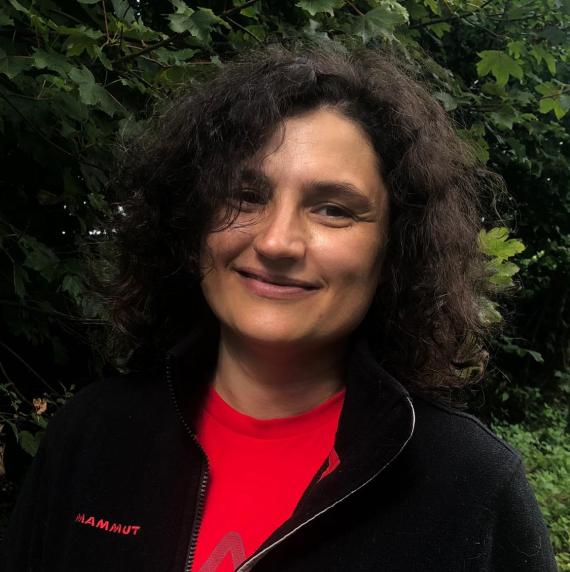 Rodica Pena in a black jumper stood in front of trees.