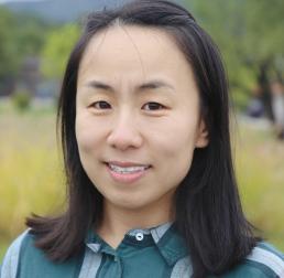 Xiaojuan Liu wearing a green checked shirt stood outside