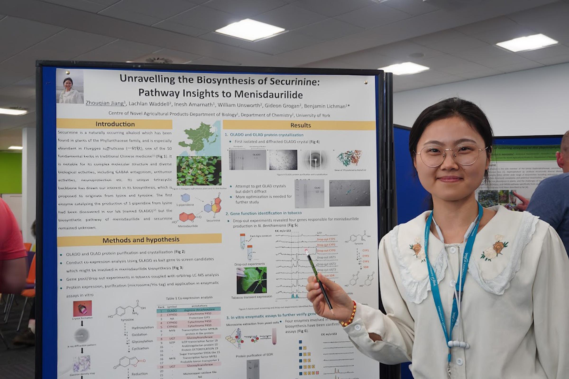 Zhouqian Jiang standing next to her poster